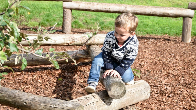 Child playing in the pavilion play area at Tyntesfield, Somerset in late autumn